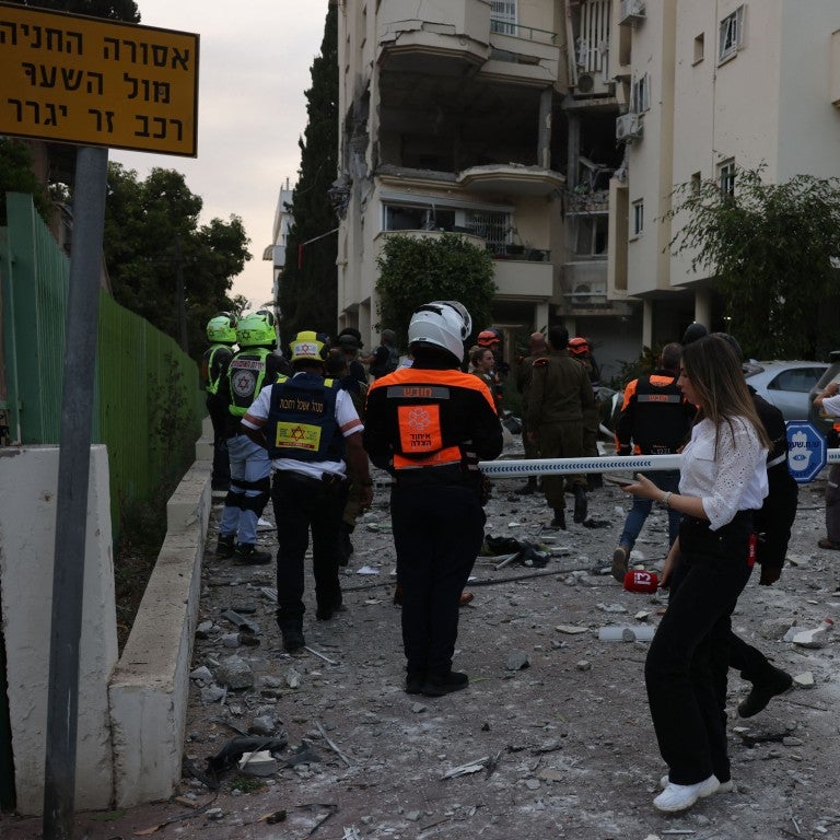 Israeli forces and rescuers secure the area near a building hit by a rocket fired from the Gaza strip, in Rehovot near Tel Aviv, on May 11, 2023.