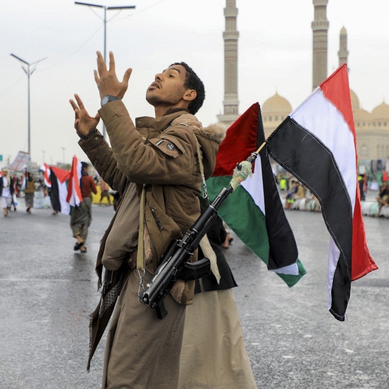 https://ajc.canto.com/b/An armed demonstrator lifting a Palestinian and Yemeni flags gestures during an anti-Israel and anti-US rally in the Huthi-controlled capital Sanaa on January 19, 2024, protesting the US designation of Yemen's Huthi rebels as "terrorists", after a series of attacks on Red Sea shipping amid ongoing battles between Israel and the militant Hamas group in Gaza. 